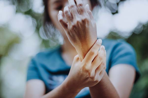 Eine Frau hält ihr schmerzendes Handgelenk